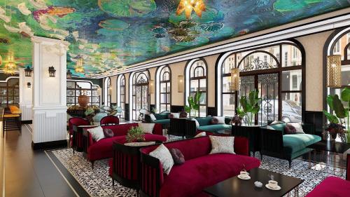 a living room with red couches and a painting on the ceiling at Grand Fleuve Boutique in Ha Long