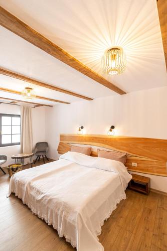 a bedroom with a large bed with a wooden headboard at Casa Sena in Moieciu de Sus
