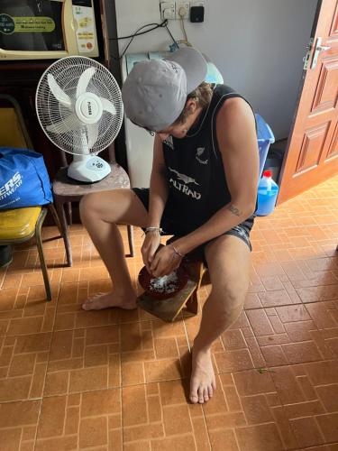 a man sitting on a chair holding a shoe at Natures Bliss Holidays in Ja-Ela
