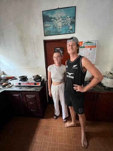 a man and a woman standing in a kitchen at Natures Bliss Holidays in Ja-Ela
