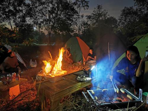 a group of people sitting around a camp fire at Kampot Camping - Eco Retreat in Kampot