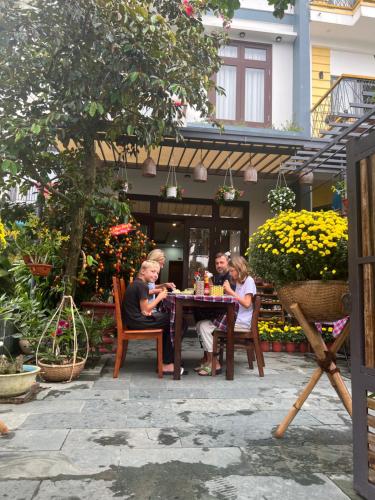 a group of people sitting at a table at Phuoc Dat Riverside Homestay Hoi An in Hoi An