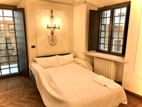a bed in a room with two windows at Borgoloto Suite 17 in San Marino
