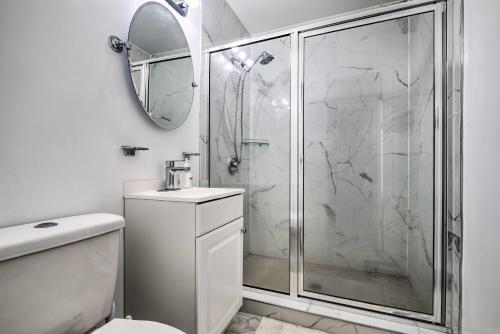 a white bathroom with a shower and a toilet at Maryland Vacation Home Near US Capital! in Riverdale Park