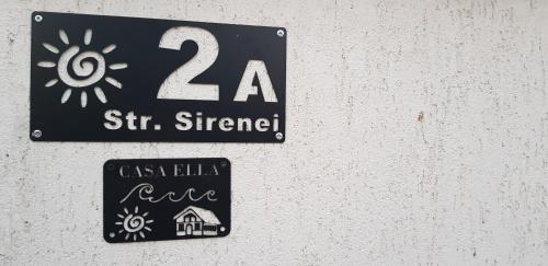 a sign on the side of a wall with a sun sign at Casa Ella in Tuzla