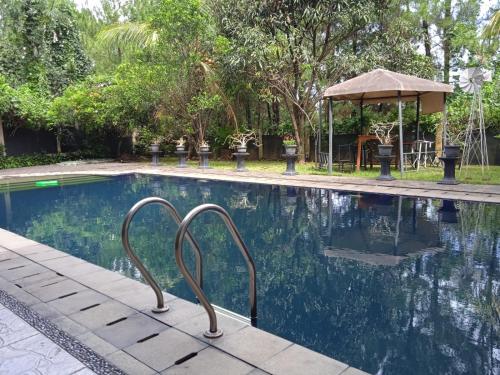 uma piscina com um corrimão de metal ao lado em Villa Gathering Yuni Syahla em Citaringgul 1