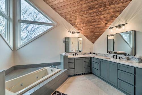een badkamer met 2 wastafels, een bad en een groot raam bij Mountaintop Wintergreen Resort House with Deck in Roseland