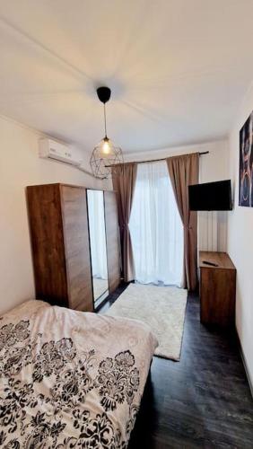 a bedroom with a bed and a large window at Belle Apartments - Republicii in Piteşti