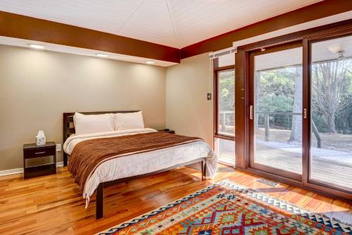 een slaapkamer met een bed en een groot raam bij Stylish and Serene West Friendship Hidden Gem! in Turf Valley