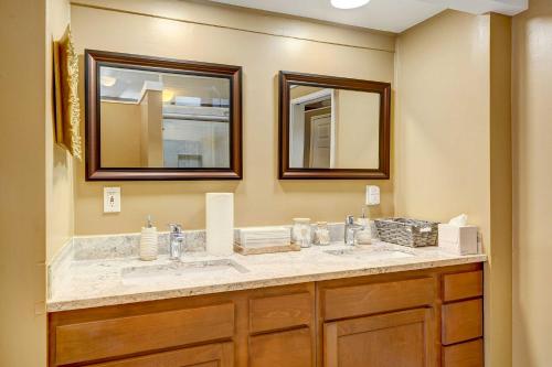 a bathroom with two sinks and two mirrors at Stylish and Serene West Friendship Hidden Gem! in Turf Valley
