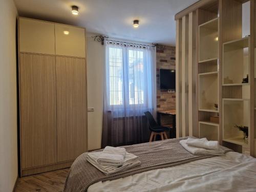 a bedroom with a bed and a desk and a window at Дом in Gyumri