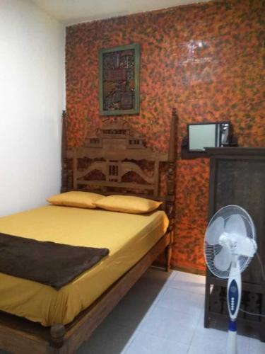 een slaapkamer met een bed en een ventilator bij 8 Up House in Betek