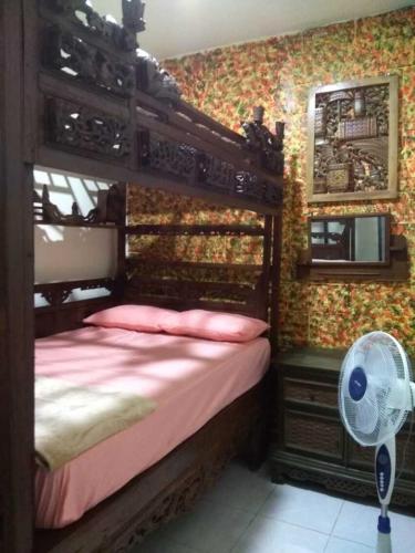 1 dormitorio con litera de madera y ventilador en 8 Up House, en Betek