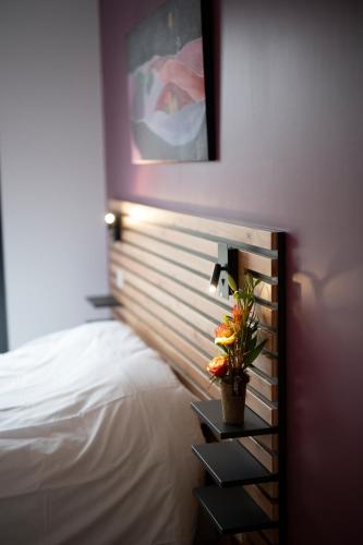 a bedroom with a bed and a plant on a shelf at L'Orée des Sources in Volvic