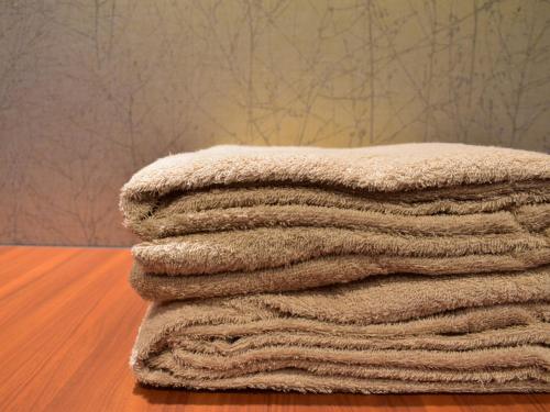 a pile of towels sitting on top of a table at Dormy Inn Premium Kyoto Ekimae Natural Hot Spring in Kyoto