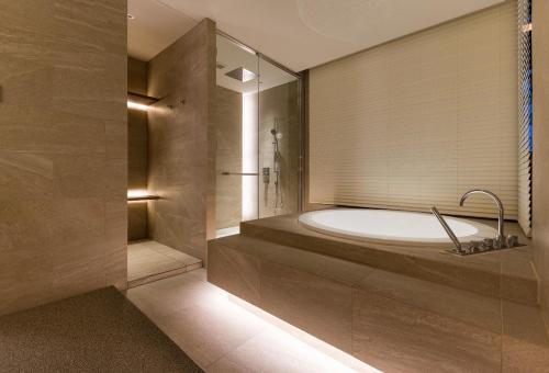 東京的住宿－THE skM TOKYO HOTEL & DINING，一间带大浴缸和淋浴的浴室