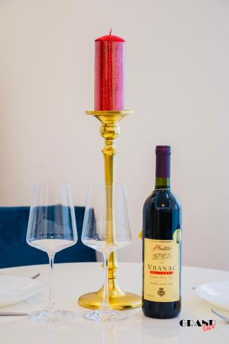 a bottle of wine and two glasses on a table at GRAND LUX Apartment in Doboj
