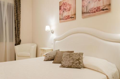 a bedroom with a white bed with two pillows on it at Taormina B&B in Taormina