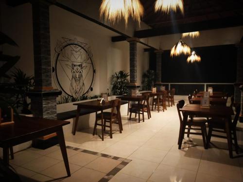 a dining room with tables and chairs and chandeliers at Batur view Homestay - Loft in Kintamani