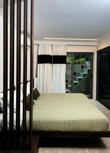 a bedroom with a bed and a window with a staircase at Cityzoe Athens Suites in Athens