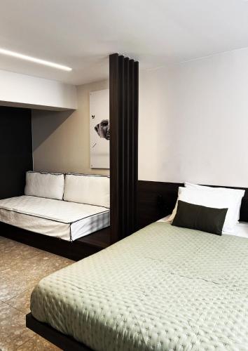 a bedroom with two beds and a couch at Cityzoe Athens Suites in Athens