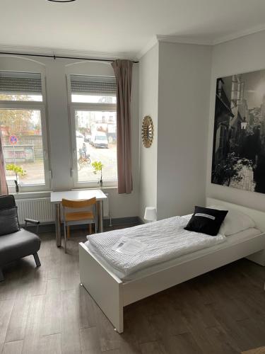 meierstrasse في لوبيك: غرفة نوم بسرير وطاولة ونافذة