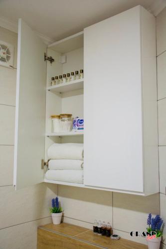 a bathroom with white towels and a mirror at GRAND LUX Apartment in Doboj