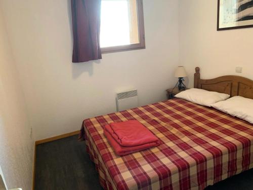 une chambre avec un lit avec une serviette rouge dessus dans l'établissement Résidence Cristallines - 3 pièces 6 personnes MAE-7264, à Orcières