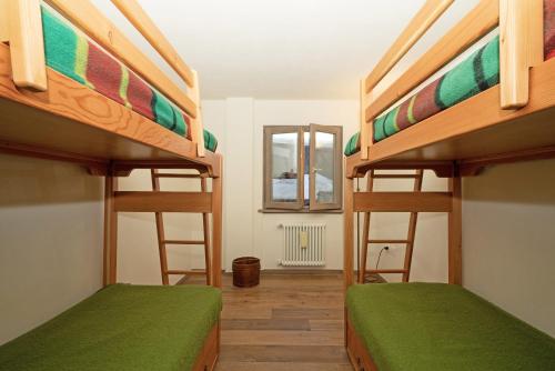 a room with two bunk beds and a mirror at Nuovo Appartamento Super Vista a Campiglio Parking Privato in Madonna di Campiglio
