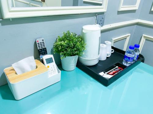 a small table with a remote control and aisk at 61 Hotel in Gua Musang