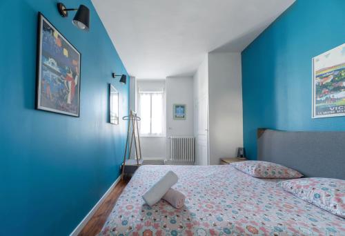 um quarto com paredes azuis e uma cama com um banco. em Le 482 - Grand Appartement design & Confort - 4 chambres em Vichy