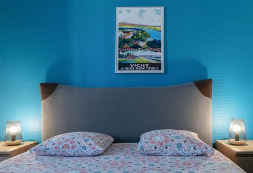 Cette chambre bleue dispose d'un lit à baldaquin sur le mur. dans l'établissement Le 482 - Grand Appartement design & Confort - 4 chambres, à Vichy