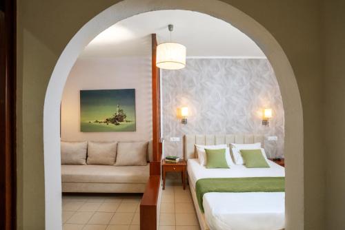 a hotel room with two beds and a couch at Philoxenia Hotel & SPA in Malia