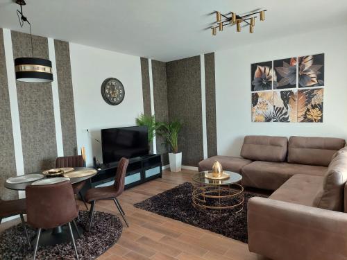 a living room with a couch and a table at Lux Apartmani Novi Park in Vrdnik