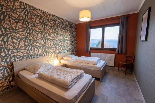 ein Hotelzimmer mit 2 Betten und einem Fenster in der Unterkunft Chalet Beau Regard in Hellert