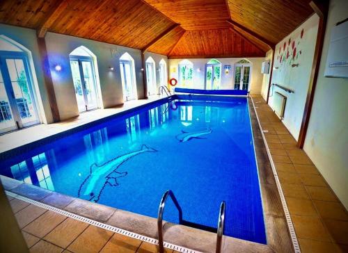 ein großer Pool mit blauem Wasser in einem Gebäude in der Unterkunft Angmering Manor Hotel in Angmering