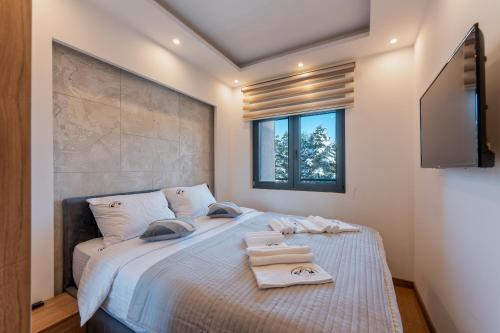 um quarto com uma cama grande e toalhas em Mount Inn La Boheme em Zlatibor