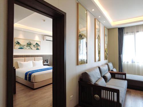 1 dormitorio con cama y sala de estar con espejo. en Escale International Hotel, en Yibuti
