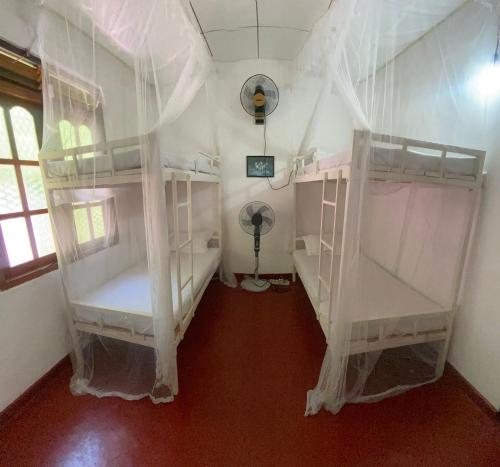 a bedroom with two bunk beds in a room at Guruge villa in Hikkaduwa