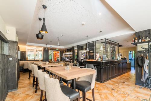 a restaurant with tables and chairs and a bar at Hotel Restaurant au Floridor in Thann