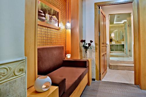 Habitación con banco y pasillo con espejo. en Grand Hilarium Hotel en Estambul
