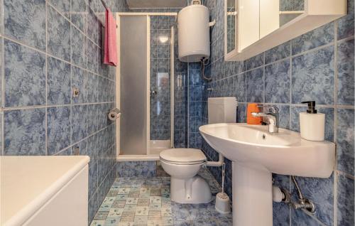 ein blau gefliestes Bad mit WC und Waschbecken in der Unterkunft Nice Apartment In Pakostane With Wifi in Pakoštane