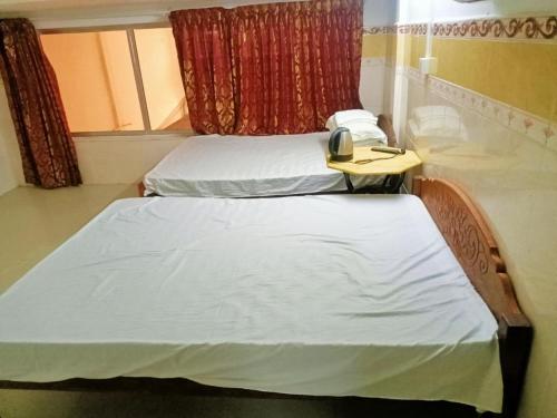 two beds in a room with a phone on a table at Good Luck Hostel in Phnom Penh