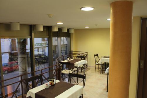 ラメトリャ・デ・マールにあるHotel del Portのテーブルと椅子、バルコニー付きのレストラン