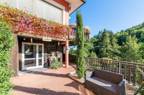 a building with a bench on a balcony with flowers at Hotel Restaurant au Floridor in Thann