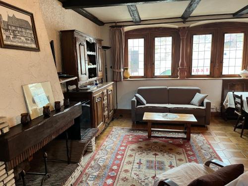 uma sala de estar com um sofá e uma mesa em Maison Dietenbeck em Wissembourg
