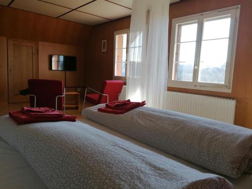 Dos camas en una habitación con toallas rojas. en Like on cloud nine - Apartment in Emmental, 