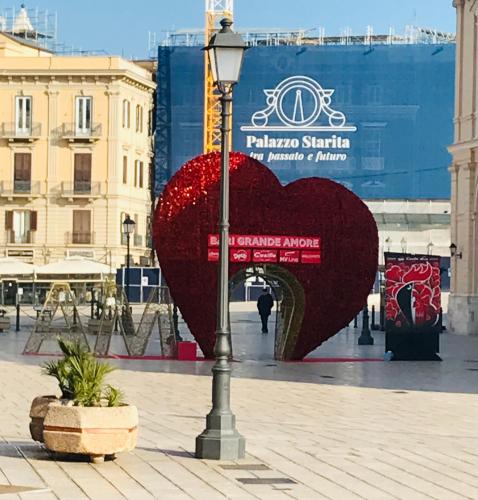 a large red heart sculpture on a city street at B&B Via dell'Azzurra in Bari