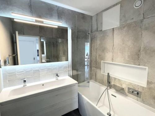 a bathroom with a sink and a tub and a mirror at Fabuleuse vue mer-Appart 110 m2 - métro et bus in Marseille