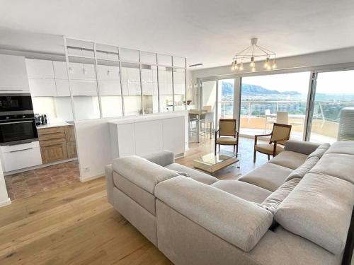 a living room with a couch and a kitchen at Fabuleuse vue mer-Appart 110 m2 - métro et bus in Marseille